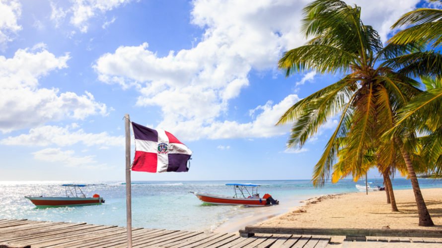 Caribbean beach and Dominican Republic flag on Saona island